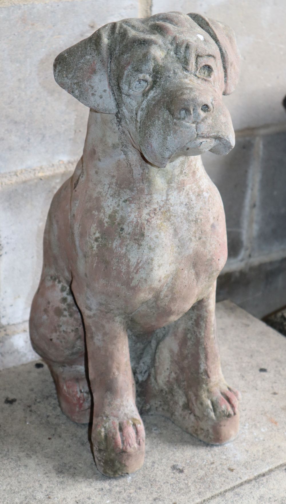 A reconstituted stone garden ornament of a seated dog, H.50cm